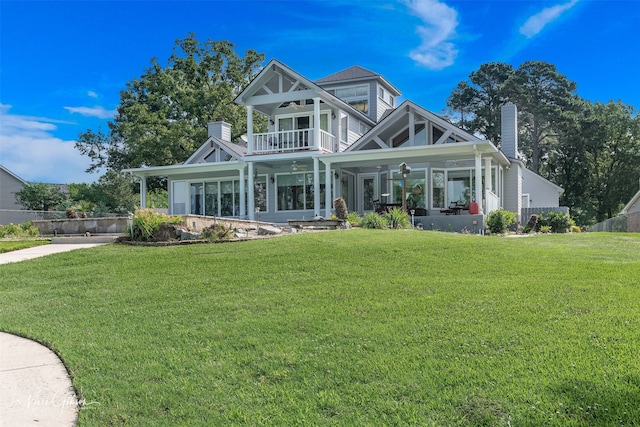 view of front of property with a porch, a balcony, a front yard, and ceiling fan