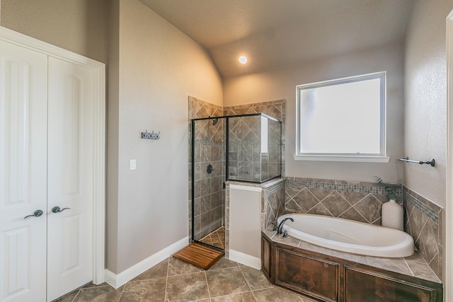 bathroom with a bath, vaulted ceiling, tile patterned flooring, and a shower stall