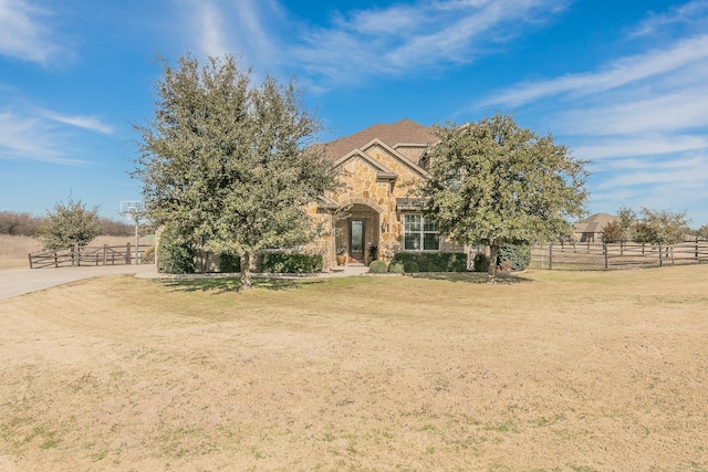 view of front facade featuring a rural view and a front lawn