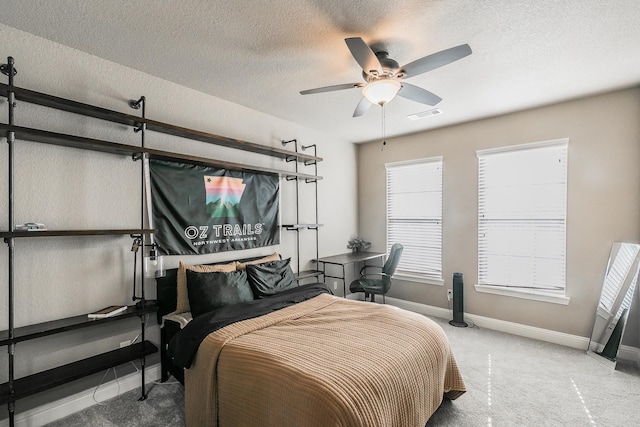 carpeted bedroom with ceiling fan and a textured ceiling