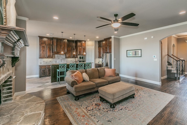 living room with recessed lighting, wood finished floors, arched walkways, a fireplace, and ceiling fan