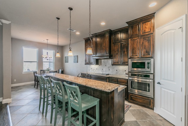 kitchen featuring a center island, decorative backsplash, a breakfast bar, appliances with stainless steel finishes, and recessed lighting