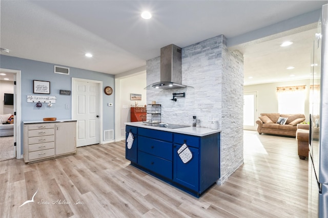 kitchen featuring blue cabinetry, wall chimney exhaust hood, black electric cooktop, and light hardwood / wood-style flooring