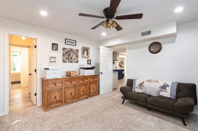 living room featuring ceiling fan and light carpet