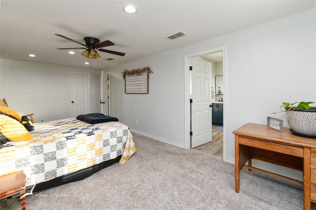 bedroom featuring connected bathroom, light carpet, and ceiling fan