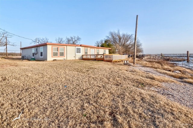 back of property with a lawn and a deck