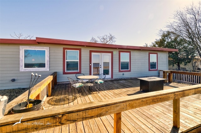 wooden deck featuring french doors and a fire pit