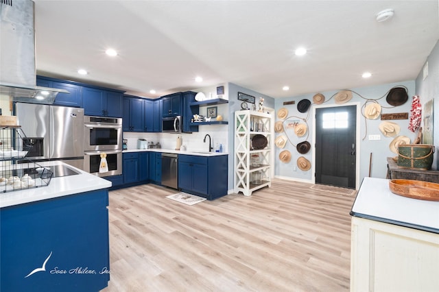 kitchen with stainless steel appliances, sink, blue cabinetry, and light hardwood / wood-style floors