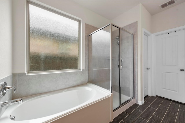 bathroom featuring a healthy amount of sunlight and shower with separate bathtub