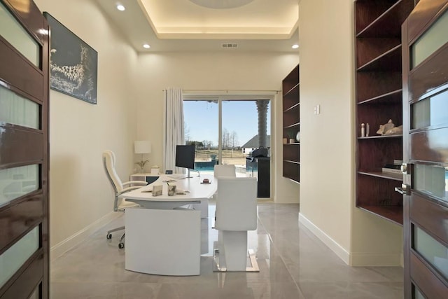 office featuring a raised ceiling and built in shelves