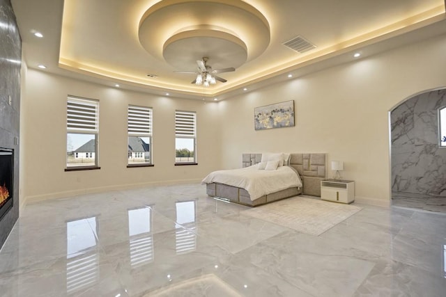 unfurnished bedroom with a fireplace and a raised ceiling