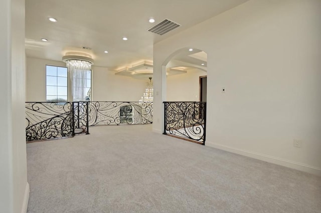 unfurnished room with an inviting chandelier and carpet flooring