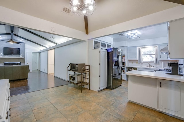 kitchen featuring sink, white cabinets, ceiling fan, wall chimney range hood, and black refrigerator with ice dispenser