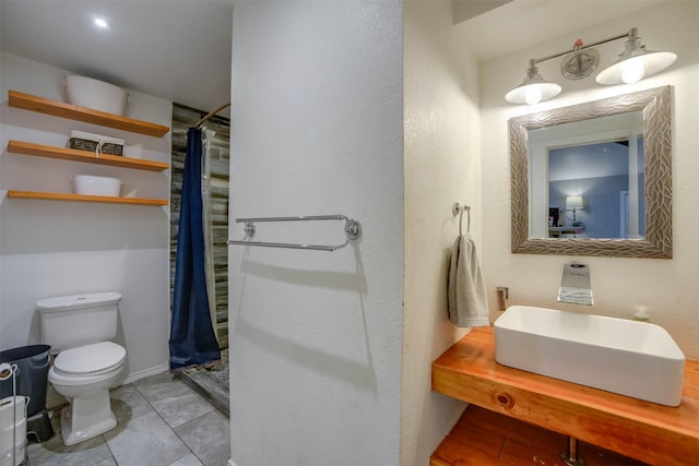 bathroom with sink, a shower with curtain, and toilet