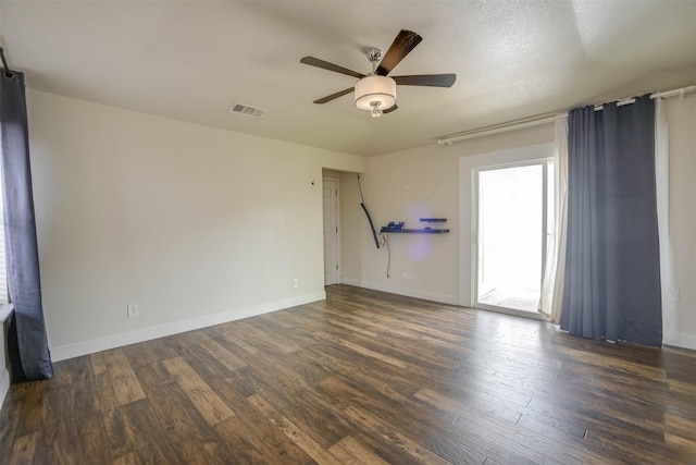 unfurnished room featuring dark wood-type flooring and ceiling fan