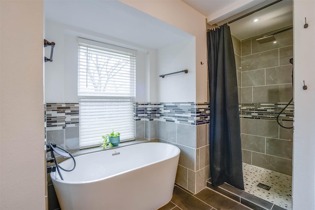 bathroom with tile walls, tile patterned flooring, and plus walk in shower