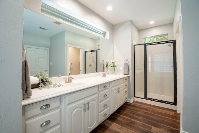 bathroom featuring hardwood / wood-style flooring, vanity, and an enclosed shower