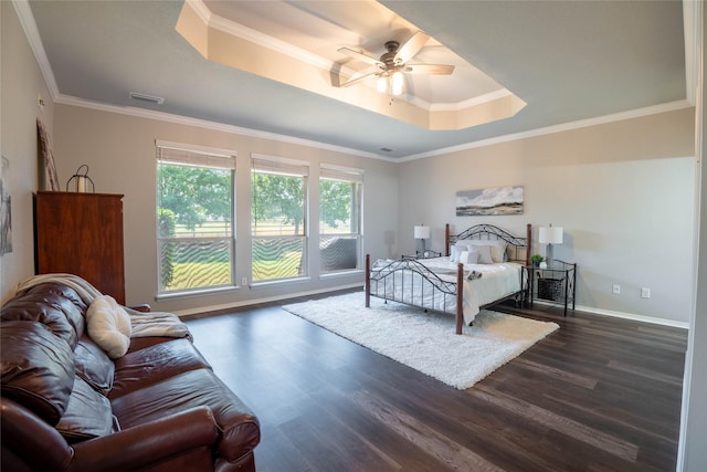 bedroom with a raised ceiling, ornamental molding, dark wood-type flooring, and ceiling fan