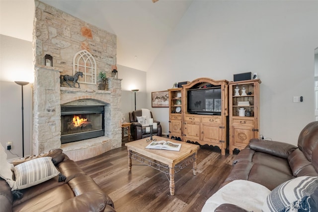 living room featuring hardwood / wood-style flooring, a stone fireplace, and high vaulted ceiling