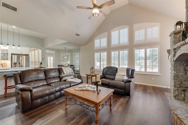 living room with ceiling fan, a fireplace, dark hardwood / wood-style flooring, and high vaulted ceiling