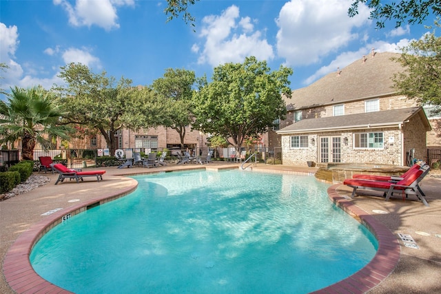 view of swimming pool featuring a patio and a jacuzzi