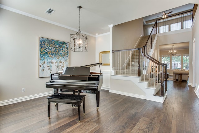 misc room with crown molding, ceiling fan with notable chandelier, and dark hardwood / wood-style flooring