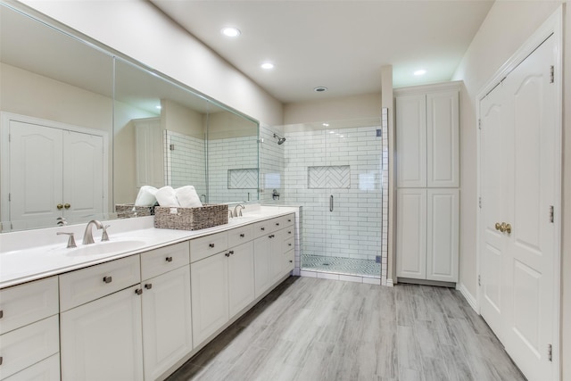 bathroom with vanity, hardwood / wood-style floors, and a shower with shower door