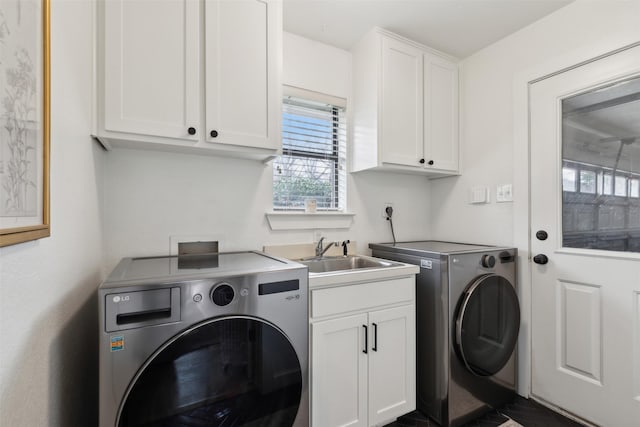 laundry area with washer and dryer, sink, and cabinets