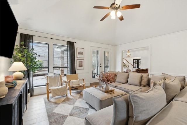 living room featuring french doors, ceiling fan, vaulted ceiling, and light wood-type flooring