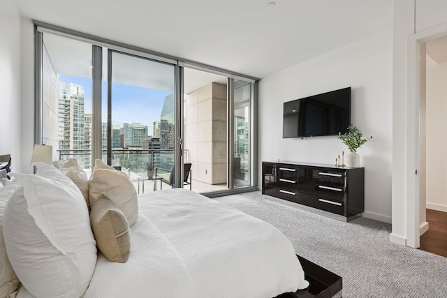 bedroom featuring floor to ceiling windows, carpet floors, and access to exterior