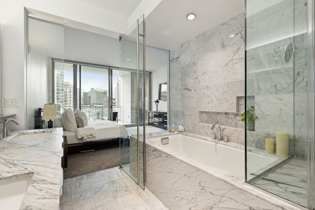 bathroom featuring a relaxing tiled tub and vanity