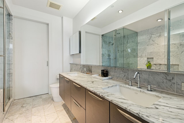 bathroom with vanity, backsplash, a shower with shower door, and toilet