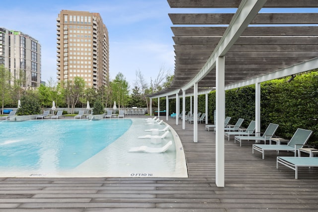 view of swimming pool with a wooden deck and a pergola