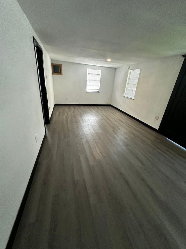 unfurnished room featuring dark hardwood / wood-style flooring and a textured ceiling