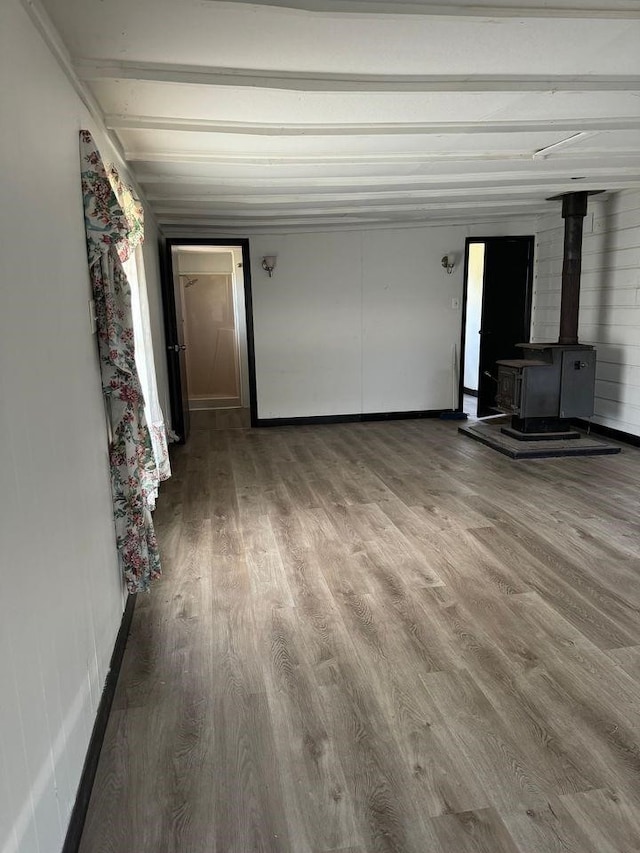 unfurnished living room featuring hardwood / wood-style floors and a wood stove