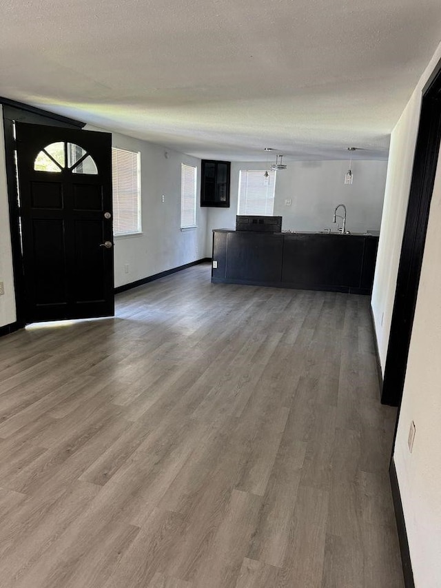 unfurnished living room with hardwood / wood-style flooring and a textured ceiling