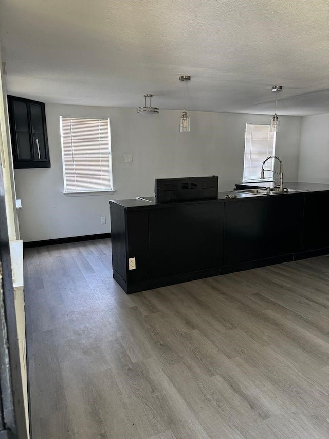 kitchen featuring pendant lighting, sink, hardwood / wood-style floors, and a textured ceiling