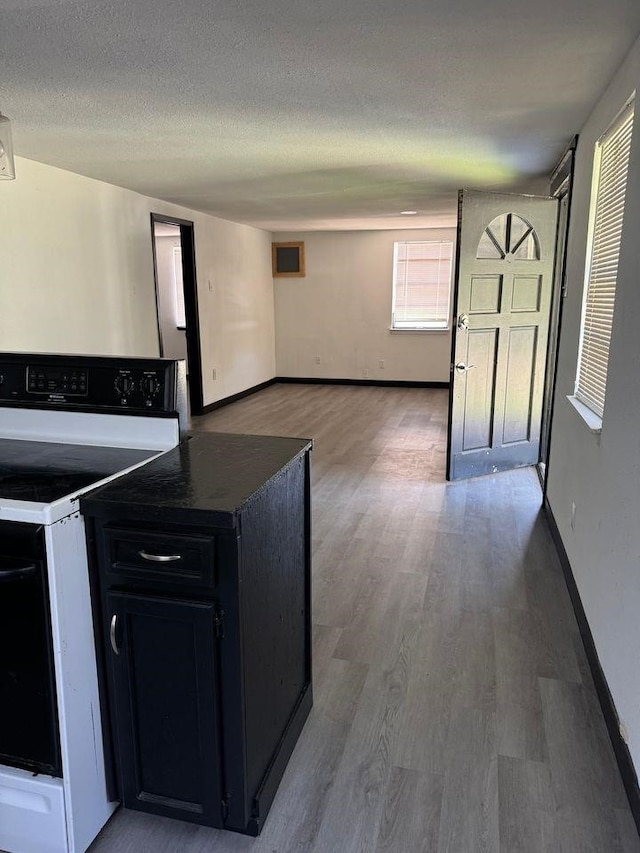 kitchen with hardwood / wood-style flooring, range with electric cooktop, and a textured ceiling