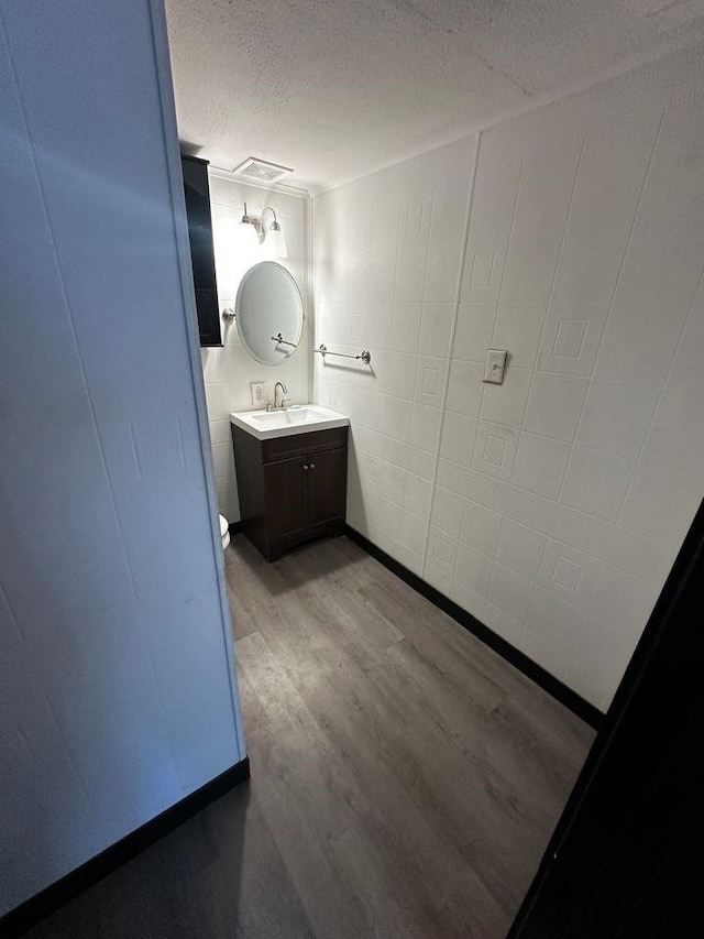 bathroom with vanity, hardwood / wood-style flooring, and a textured ceiling