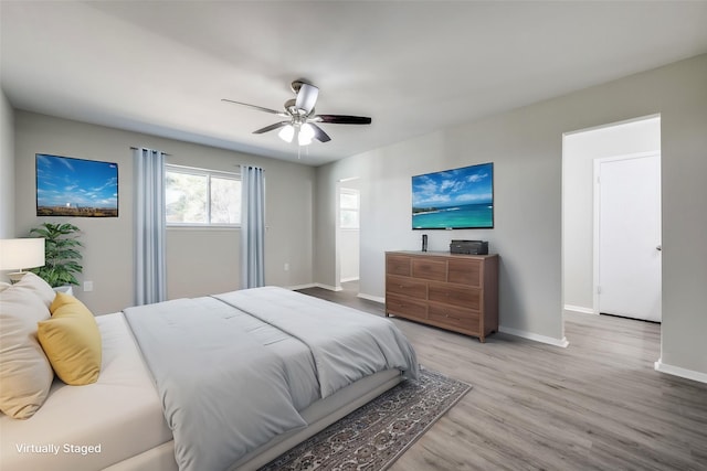 bedroom with ceiling fan, baseboards, and wood finished floors