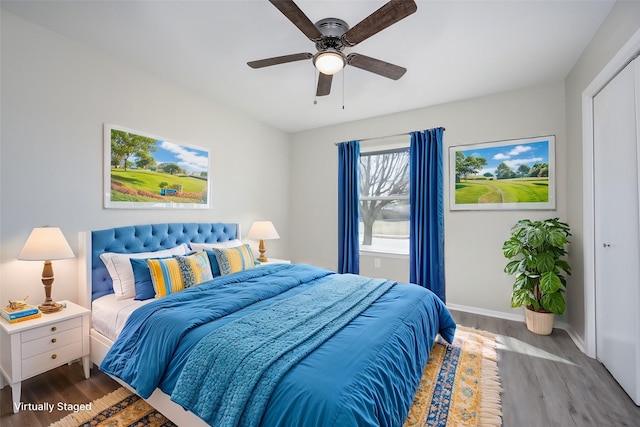 bedroom with ceiling fan, baseboards, and wood finished floors