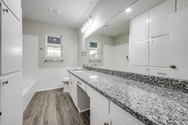 full bath featuring visible vents, baseboards, toilet, wood finished floors, and vanity