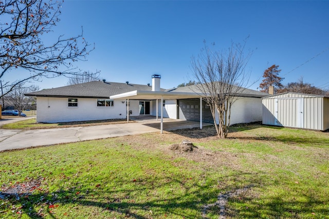 back of house featuring an outbuilding, a shed, an attached garage, a yard, and concrete driveway