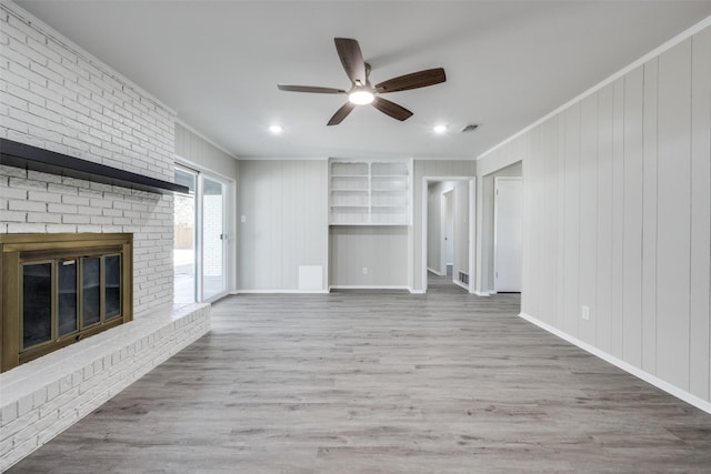 unfurnished living room featuring crown molding, a fireplace, and hardwood / wood-style floors