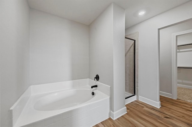 bathroom with hardwood / wood-style flooring and independent shower and bath