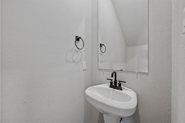 bathroom featuring sink and vaulted ceiling