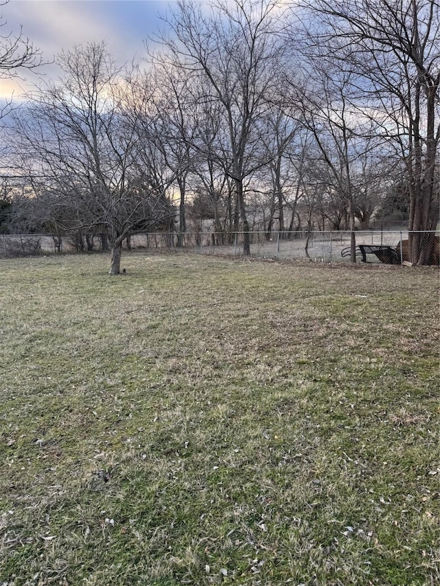 yard at dusk featuring fence