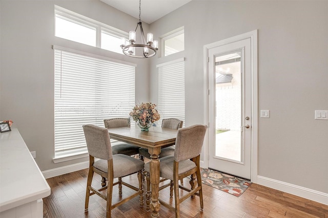 dining room with an inviting chandelier, a wealth of natural light, and wood-type flooring