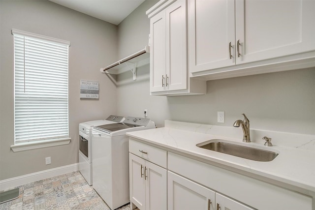 washroom featuring washer and dryer, sink, and cabinets