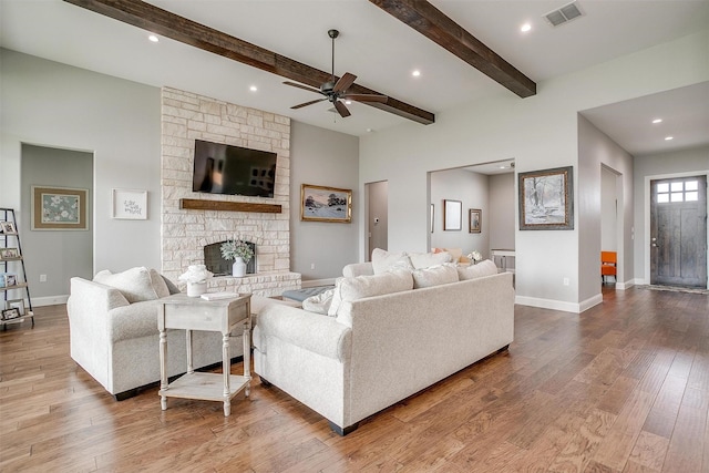 living room with beam ceiling, hardwood / wood-style flooring, a fireplace, and ceiling fan